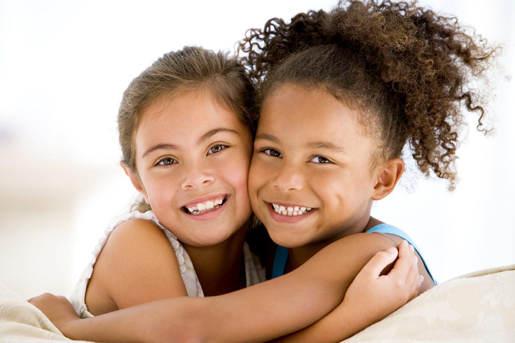 Two girls smiling to the camera for a picture